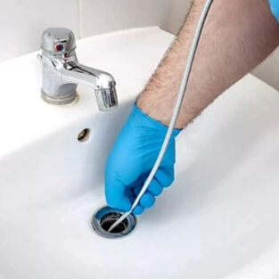 A Professional Plumber cleaning a sink